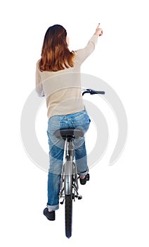 Back view of pointing woman with a bicycle.