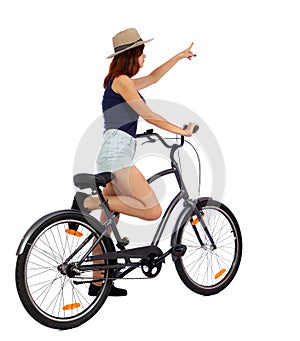 Back view of pointing woman with a bicycle. cyclist sits on the bike.