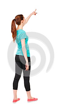 Back view of pointing woman in sportswear.