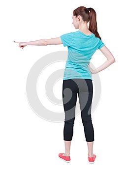 Back view of pointing woman in sportswear.