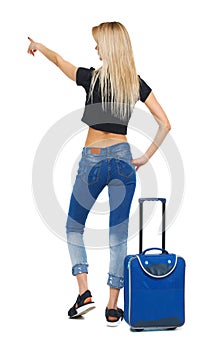 Back view of  pointing woman with suitcase pointing
