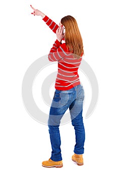 Back view of pointing young beautiful woman and using a mobile
