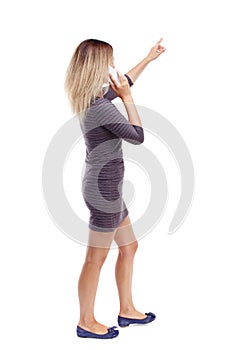 Back view of pointing young beautiful woman and using a mobile