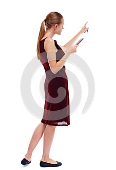 Back view of pointing young beautiful woman and using a mobile