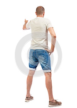 Back view of pointing young men in shirt and jeans.