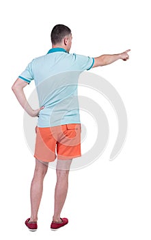 Back view of pointing young men in t-shirt and shorts.