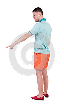 Back view of pointing young men in t-shirt and shorts.