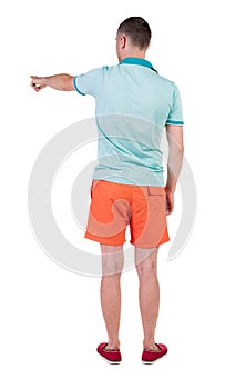 Back view of pointing young men in t-shirt and shorts.