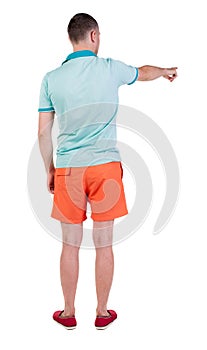 Back view of pointing young men in t-shirt and shorts.