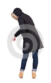 Back view of pointing young woman in parka.