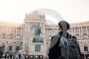 Back view portrait of Asian male tourist backpacker carrying a bag in Hofburg palace in Vienna, Austria