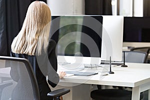 Back view portrait of a casual businesswoman working on computer