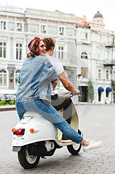 Back view portrait of a stylish young couple riding