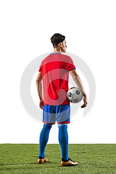 Back view portrait of young caucasian soccer football player i uniform holding ball isolated on grass flooring white