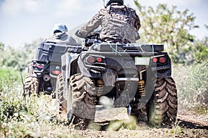 Back view of quad bike riding along a country road.