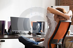 Back view or redhead male employee relax in office chair