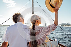 Back view of relaxed mature couple sitting on yacht