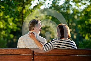 Back view retired senior couple on the bench.