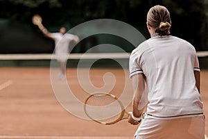 back view of retro styled tennis players during game