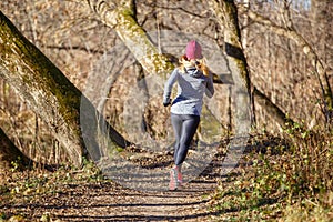 Back view of running girl in fall park in morning