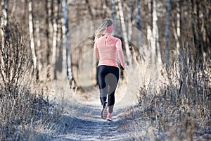 Back view of running girl in fall park in morning