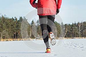 Back view of running sportsman during cross country race outdoor in winter forest