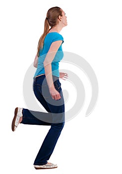 Back view of running woman in jeans