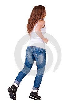 Back view of running woman in jeans