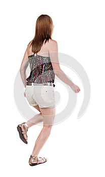 Back view of running woman in shorts