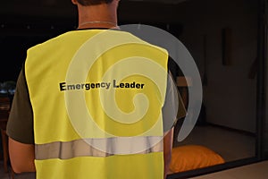 Back view of a safety profesional wearing  an emergency leader yellow vest.