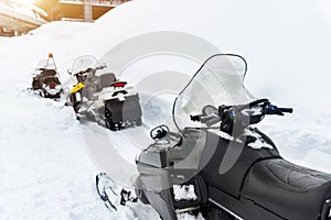 Back view scene many modern snow mobile scooter atv vehicle forest road against woods on cold snowy winter day