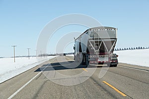 Back view of a semi truck travelling down the highway