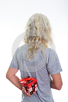 Back view of senior bearded man hiding red gift box behind back