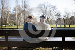 Back view of senior couple calmly sitting on bench