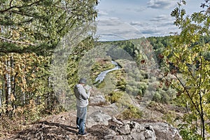 Senior male hiker, exploring route on map of Nature park Deer streams, Russia.