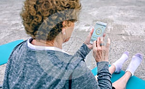 Back view of senior woman using smartphone