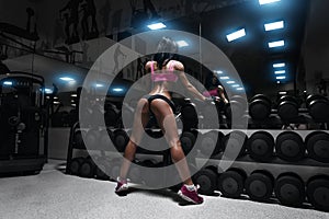 Back view of young brunette woman resting in the gym