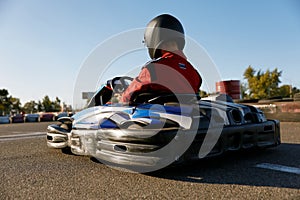 Back view shot of competitive racer driving go-cart sports track