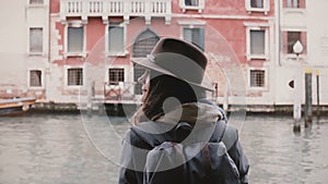 Back view shot of happy peaceful young woman tourist enjoying atmospheric gondola trip along Venice canals in Italy.