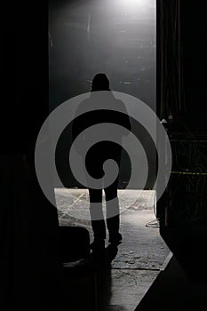 Back view of a silhouette of a man in a dark corridor