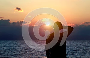Back view silhouette photo of depressed man watching the sunset on the sea.