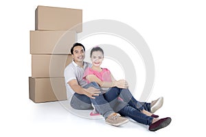 Back view of sitting cute couple with stack of cardboard boxes