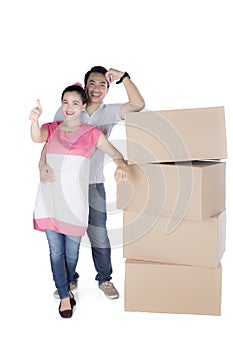 Back view of sitting cute couple with stack of cardboard boxes