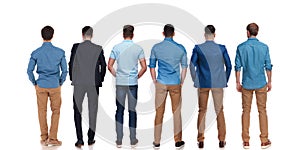 Back view of six relaxed young men standing