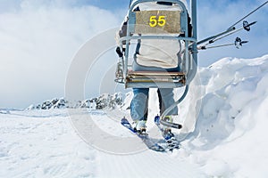 Back view of skier riding a lift.