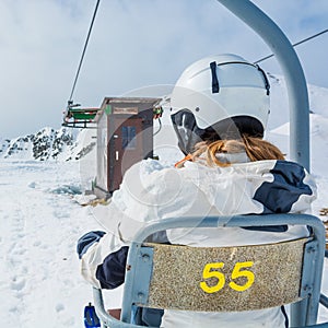 Back view of skier riding a lift.