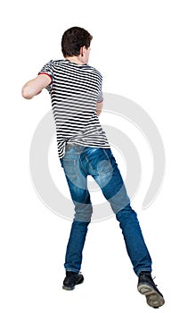 Back view of skinny guy funny fights waving his arms and legs.