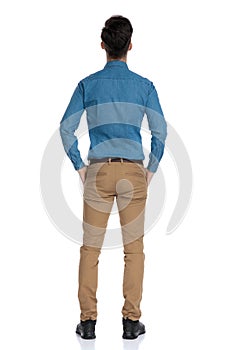 Back view of smart casual man in blue shirt looking up