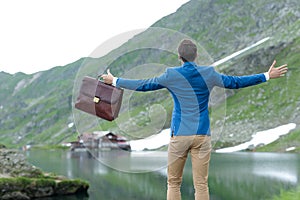 Back view of smart casual man opening arms and embracing the nature