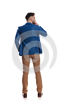 Back view of smart guy thinking with hand at chin